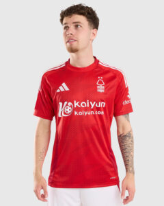 Male model wearing a red Nottingham Forest soccer jersey with white stripes and sponsor logos, looking up and to the left.