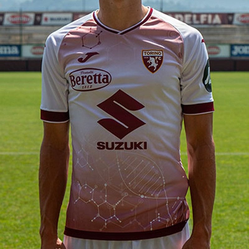 UTb8ZpNbJGH0KYB | UAE SPORT STORE Soccer player torso in a white Torino FC jersey on a sunny field, showcasing Suzuki and Beretta logos and club crest.