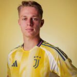 Portrait of a young man wearing a yellow Juventus football jersey, looking at the camera against a pale yellow background.
