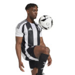 Soccer player in Juventus black-and-white kit balancing a ball at chest height.