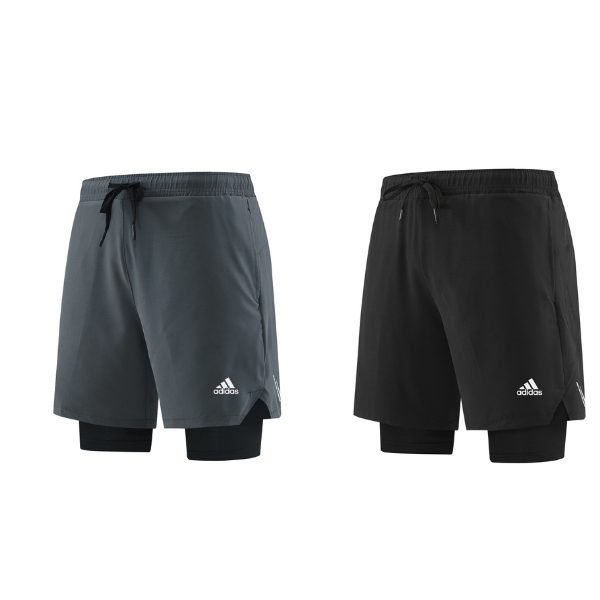 Two adidas athletic shorts in gray and black, each worn over a black compression layer, with drawstring waists and visible logo on the lower leg.