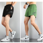 Side-by-side photos of a male model wearing Nike running shorts: left in black with pocket and dotted hem pattern, right in green with same design, paired with white sneakers.