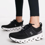 Black On brand running shoes with a white sculpted sole and laced upper in a side view.
