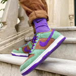 Colorful sneakers on stairs: green suede with purple Nike swoosh and purple accents, wearer in brown pants and purple socks.
