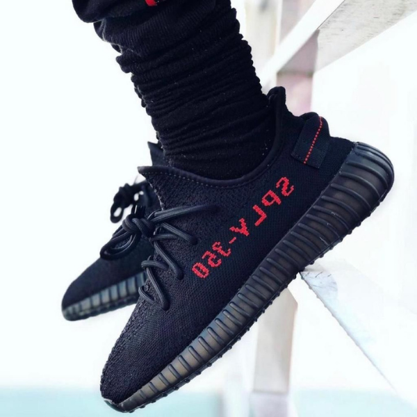 Black athletic sneakers with red 'SPLY-350' lettering on the side, worn with black ribbed socks.