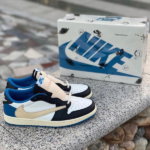 Pair of white, black, blue, and beige Nike sneakers resting on a stone ledge with a Nike shoebox in the background.