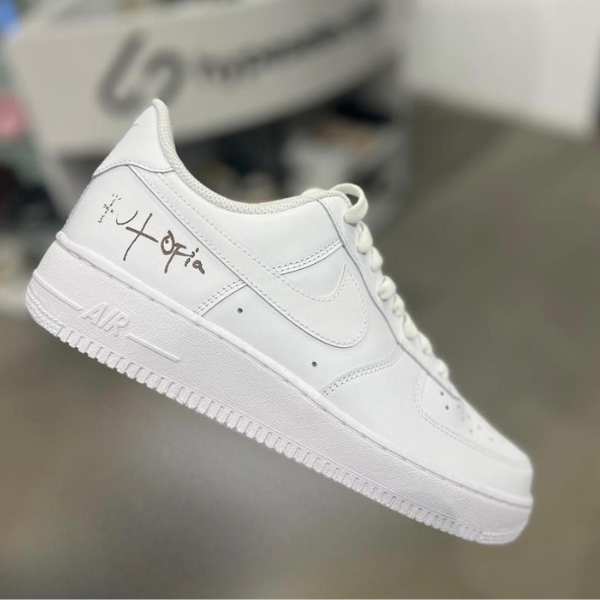 White low-top sneaker with a handwritten autograph on the heel area.