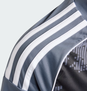 Close-up of a blue sports jersey shoulder with three white stripes running along the seam. Inset fabric texture visible.