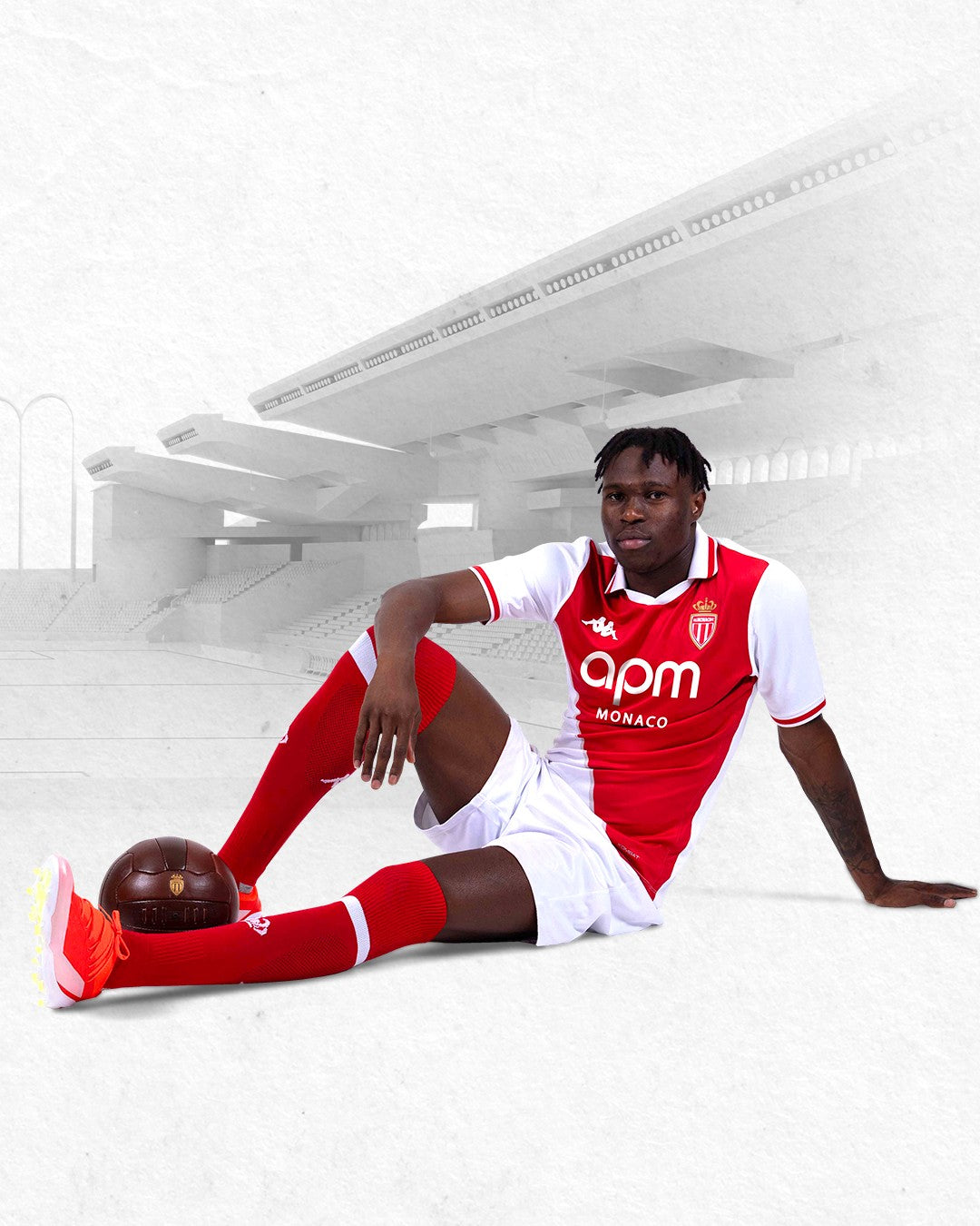 VCEVG3Rjd29lpDZ | UAE SPORT STORE Footballer in AS Monaco kit sitting on the pitch with a brown football near his foot.