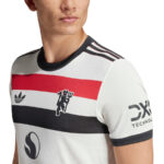 Close-up of a man wearing a white athletic jersey with red and black horizontal stripes and logos on the chest and sleeve.