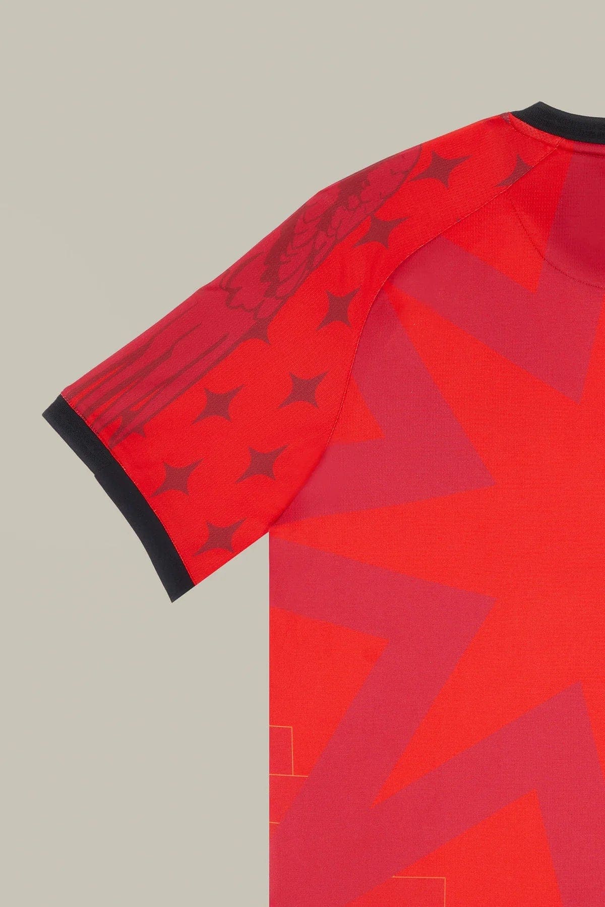 VeneziaFC-35 | UAE SPORT STORE Close-up of a red athletic jersey sleeve with a black cuff and geometric star patterns on the fabric read as a design detail.