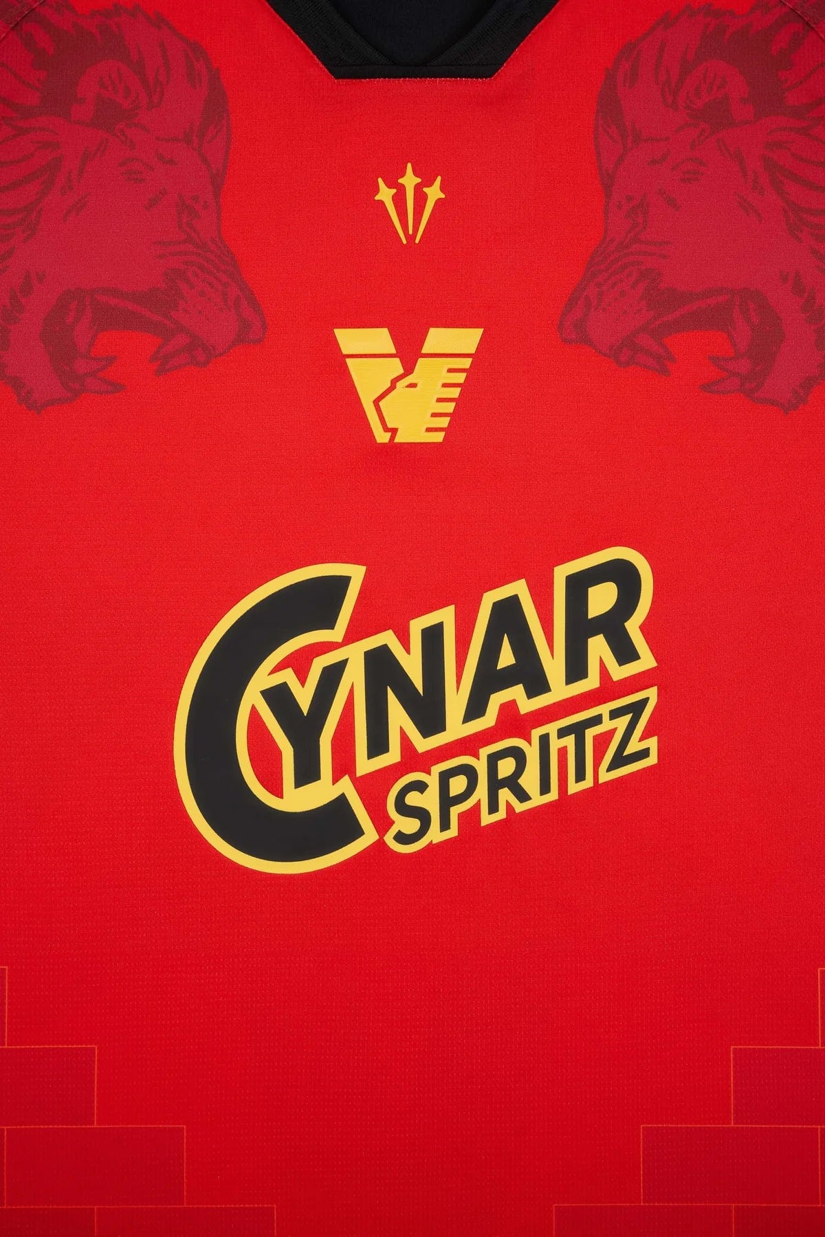 VeneziaFC-40_1 | UAE SPORT STORE Red promotional jersey fabric with bold yellow 'Cynar Spritz' logo and small crest above, flanked by subtle bear silhouettes on the sides.