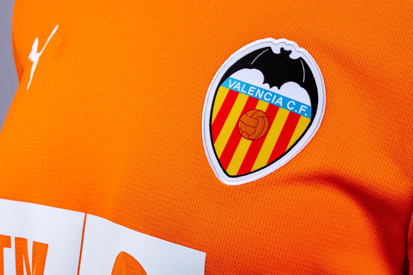 WErqPn7j9sPRSSR | UAE SPORT STORE Valencia CF crest on an orange jersey featuring red-yellow stripes, a blue name banner, and a black bat silhouette in the top.