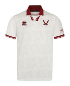White polo shirt with a subtle geometric pattern, red collar trim, and red sleeve cuffs; features an Errea logo on the left chest and a red V-shaped crest on the right chest.