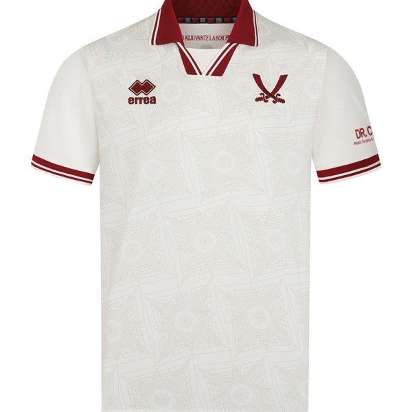 White polo shirt with a subtle geometric pattern, red collar trim, and red sleeve cuffs; features an Errea logo on the left chest and a red V-shaped crest on the right chest.