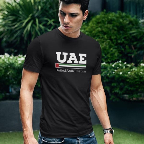 WhatsAppImage2020-11-24at7.53.51PM_1_f0d69832-d768-44fd-9b43-15c168e834e0 | UAE SPORT STORE Young man in a black T-shirt with 'UAE United Arab Emirates' text, standing outdoors among greenery and a modern building.