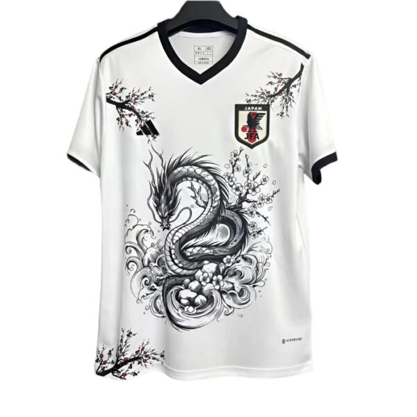 White soccer jersey with black trim featuring a large black dragon graphic and Japan JFA crest on the chest.
