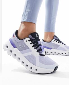 Light purple running shoes with black laces and a chunky white sole with circular cutouts, worn by a person in light leggings.] , but let's fix formatting.
