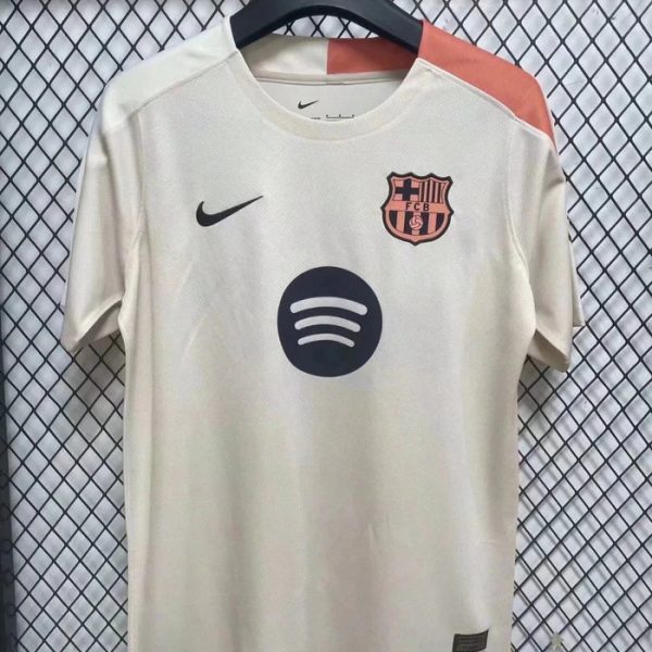 White FC Barcelona football jersey on a hanger, featuring the Nike swoosh, club crest, and Spotify sponsor logo on the front.