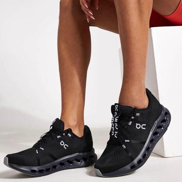 Person wearing black On-brand athletic sneakers with a distinctive hollow, pod-like sole.