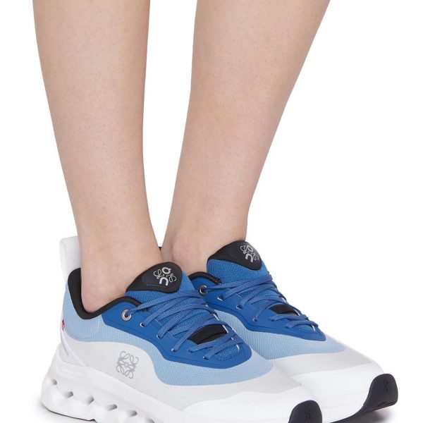 Close-up of legs and feet wearing blue and white chunky sneakers with a thick white sole.