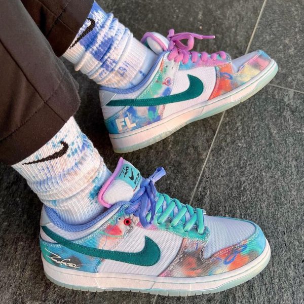 White Nike sneakers with teal swoosh and pastel tie-dye panels, turquoise and purple laces.