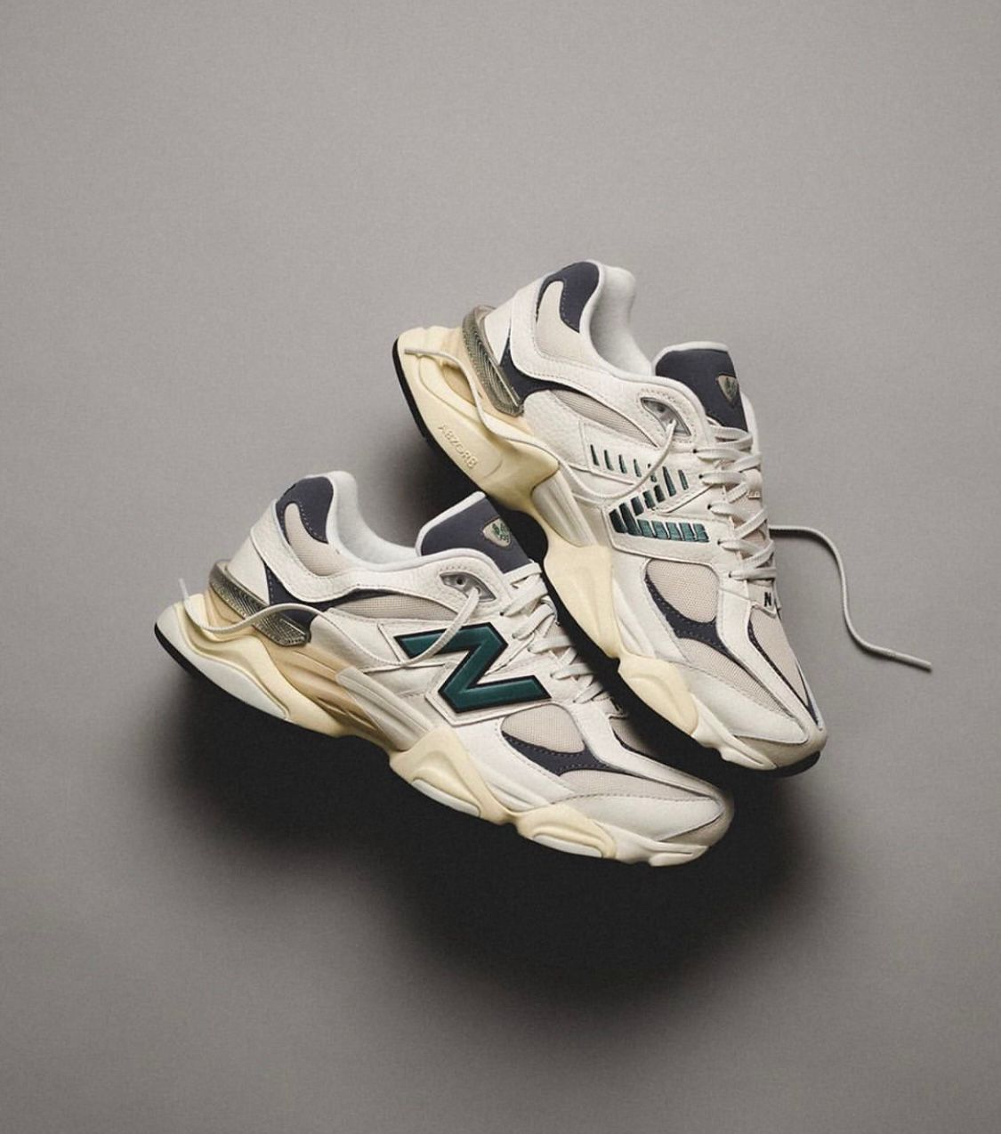 WhatsApp_Image_2024-07-27_at_00.39.04 | UAE SPORT STORE Pair of white New Balance sneakers with teal NB logo lying on a gray surface, laces loose.