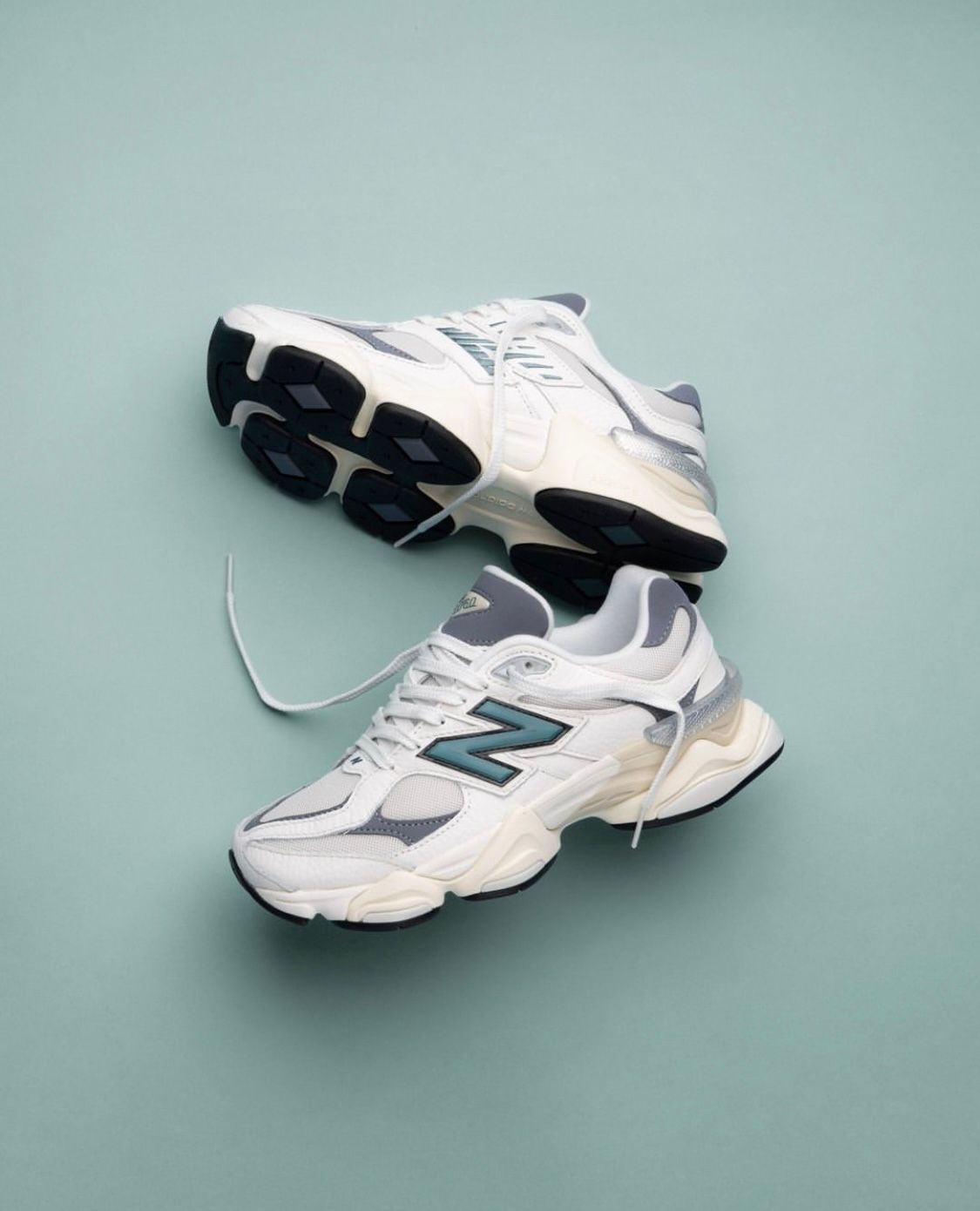 WhatsApp_Image_2024-07-27_at_00.39.24 | UAE SPORT STORE Pair of white and gray sneakers on a pale teal background, one lace loosened for a casual look.