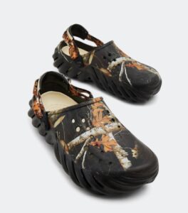 WhatsApp_Image_2024-09-06_at_11.31.54 | UAE SPORT STORE Black camouflage garden clogs with a chunky sole, ventilation holes, and a back strap featuring an autumn leaf print.