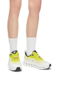 WhatsApp_Image_2024-09-09_at_09.47.26 | UAE SPORT STORE Person wearing bright yellow athletic sneakers and white crew socks, viewed from the front/low angle.