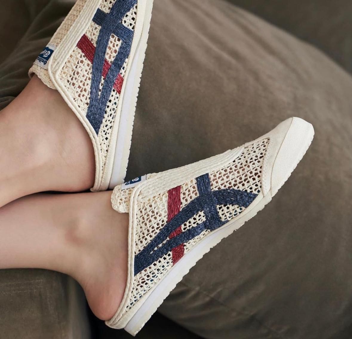 WhatsApp_Image_2024-10-03_at_10.53.10_a8a793a6-c028-407c-8290-9cd2fc40fe54 | UAE SPORT STORE Cream woven slip-on sneakers with blue and red stripes resting on a sofa, showing the side and sole.