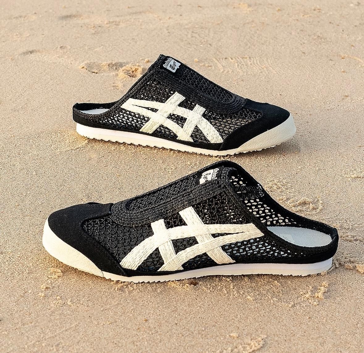 WhatsApp_Image_2024-10-03_at_15.09.57 | UAE SPORT STORE Black mesh slip-on shoes with white crisscross stripes on sandy beach surface.