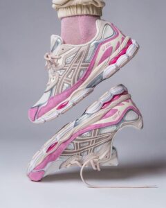 Pair of pink and grey ASICS running shoes stacked midair, showing side and sole details