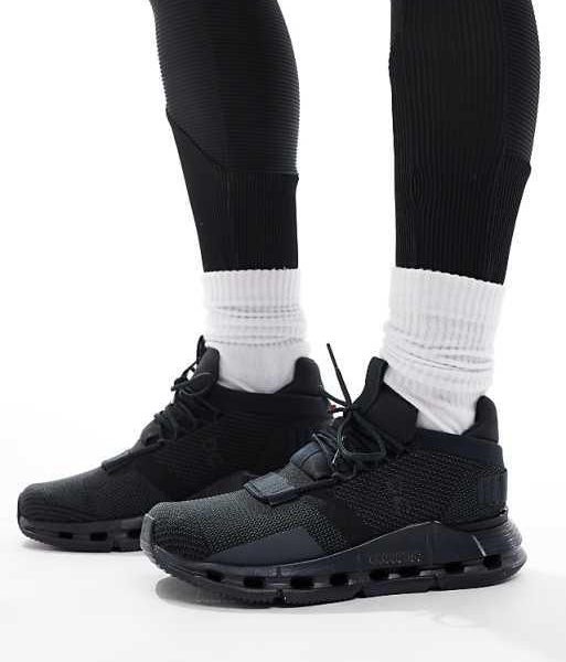 Close-up of black athletic sneakers with white crew socks on feet, lifestyle product shot