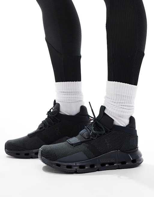 Close-up of black athletic sneakers with white crew socks on feet, lifestyle product shot