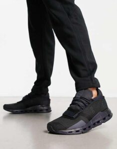 WhatsApp_Image_2024-11-06_at_11.22.29 | UAE SPORT STORE Close-up of black running shoes with a chunky sole, worn with black joggers, as the person takes a step forward.