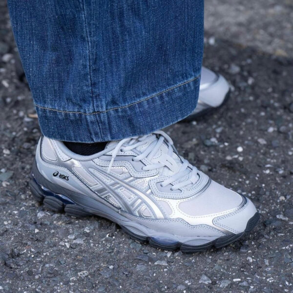 WhatsApp_Image_2024-11-08_at_11.04.46 | UAE SPORT STORE Gray Asics running shoe with white accents on a person wearing blue jeans, standing on pavement.