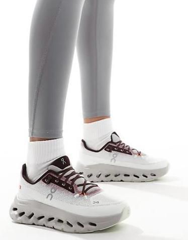 White athletic sneakers with chunky gray soles, worn with light gray leggings.