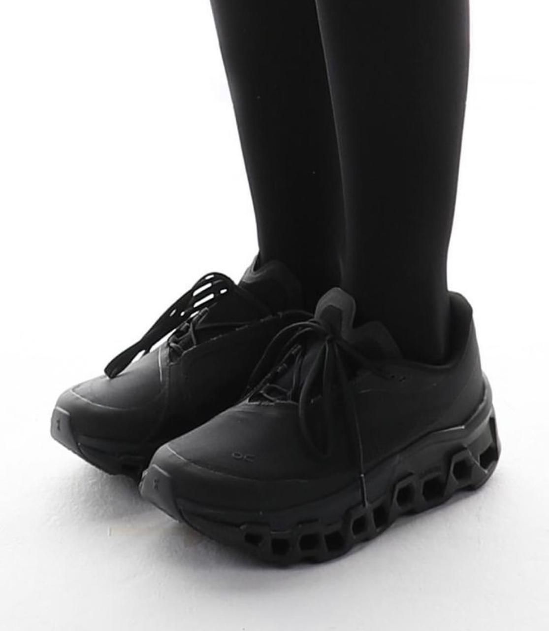 WhatsApp_Image_2024-11-12_at_14.02.57 | UAE SPORT STORE Person wearing black leggings standing in black chunky sneakers on a white surface.