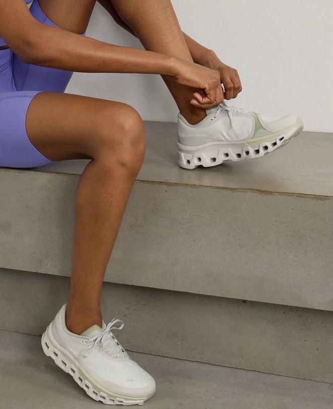 WhatsApp_Image_2024-11-12_at_16.50.09 | UAE SPORT STORE Person in lavender athletic wear ties the laces of white sneakers while seated on concrete steps.