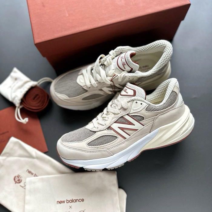 WhatsApp_Image_2024-12-04_at_12.23.53 | UAE SPORT STORE Beige New Balance sneakers with white soles, placed on a dark surface beside a brown box and dust bags. Visible burgundy NB logo on the side and tongue label.