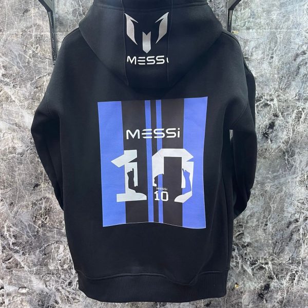 Black hoodie hanging on a rack, showing a large blue-and-black back graphic with the word 'MESSI' and the number 10.