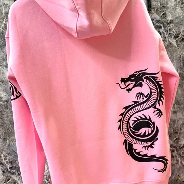 Back view of a pink hoodie with a bold black dragon graphic along the lower right back.