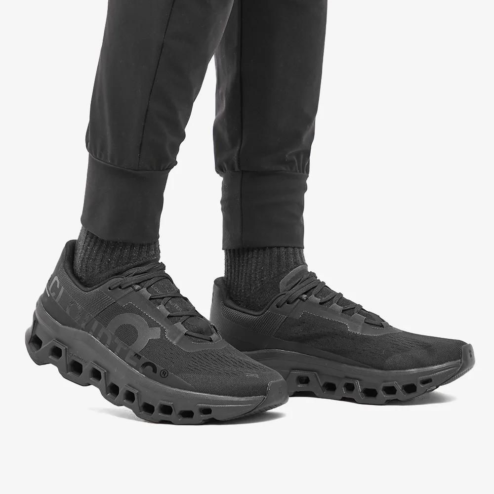 WhatsApp_Image_2025-01-27_at_10.42.48 | UAE SPORT STORE Black athletic sneakers with a vented, cube-cut sole and knit upper, shown on a person wearing black pants and socks.