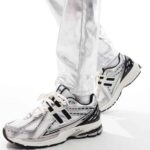 WhatsApp_Image_2025-02-13_at_14.22.37 | UAE SPORT STORE Close-up of white and silver running shoes stepping forward, showing the tread and design details on the sneakers.