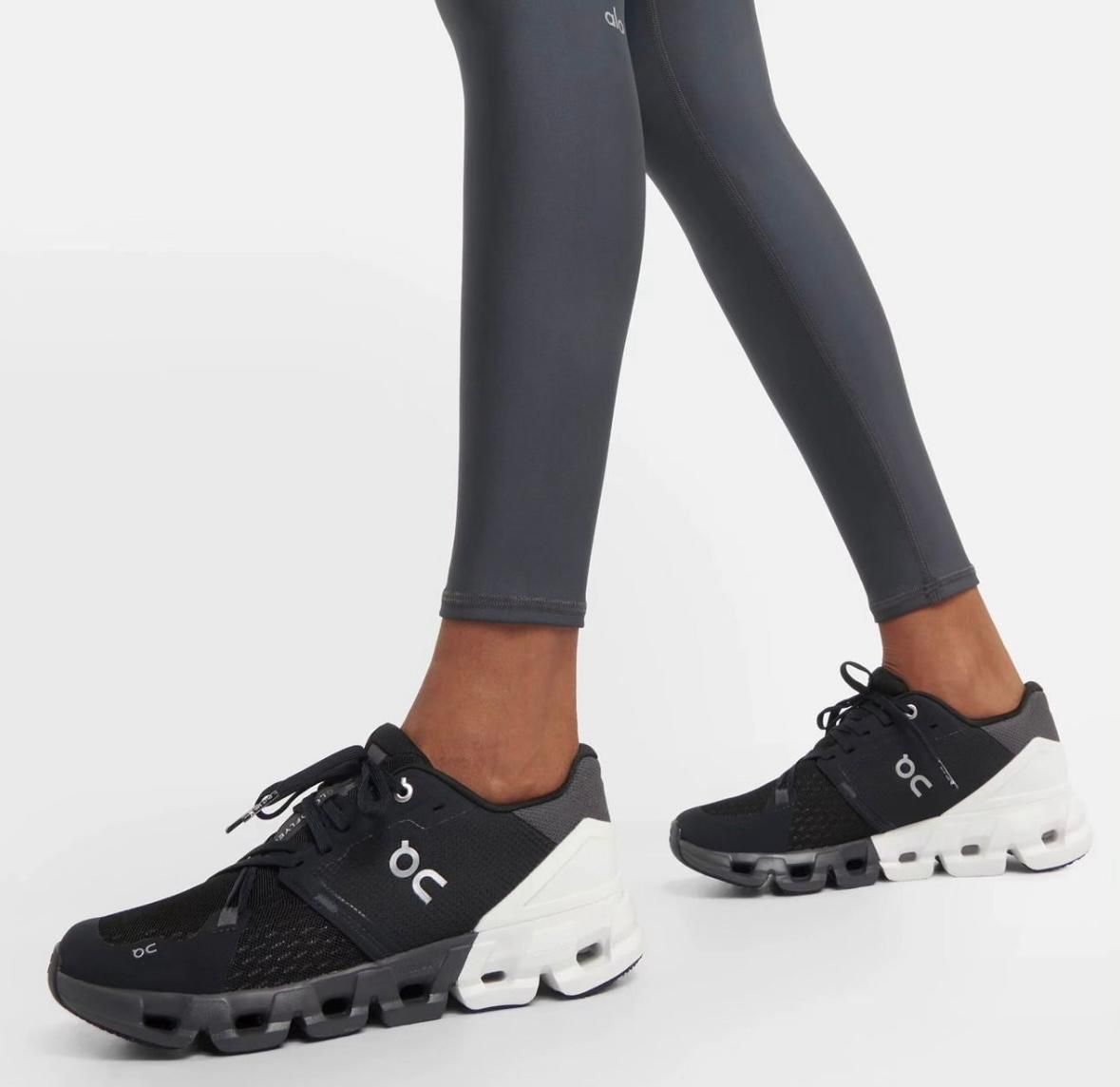 WhatsApp_Image_2025-02-16_at_13.15.59 | UAE SPORT STORE Black athletic sneakers with white chunky soles worn with dark leggings, side view showing logo 'on' and perforated upper details for a fitness look.