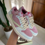 Pastel pink and light blue Nike Air sneakers with cream laces held in a hand.