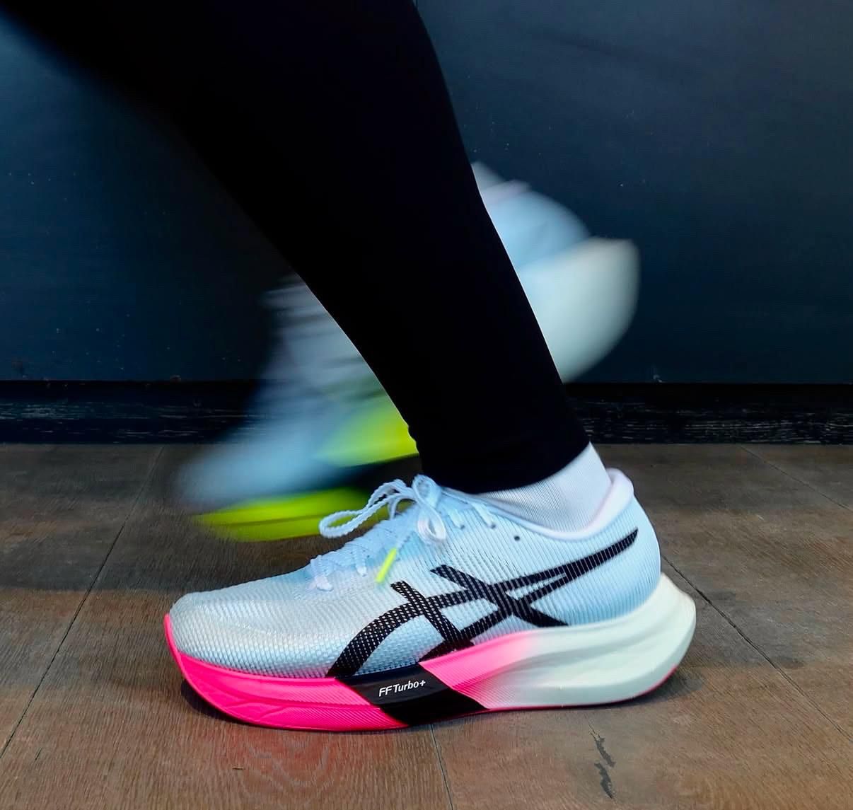 WhatsApp_Image_2025-05-19_at_12.10.49 | UAE SPORT STORE Close-up of a white running shoe with pink and neon accents in mid-step, motion blur showing forward movement.
