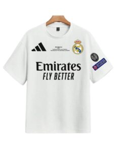White Real Madrid soccer jersey on a wooden hanger, featuring Emirates Fly Better sponsor logo and club crest with patch on the sleeve.