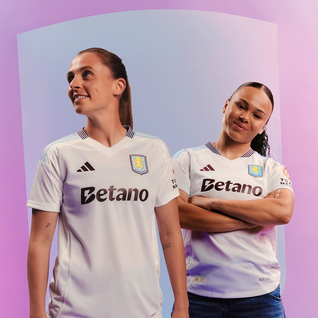 Xi5DYXtlPutMnAo | UAE SPORT STORE Two female football players in white Aston Villa jerseys standing against a purple gradient backdrop with smiles